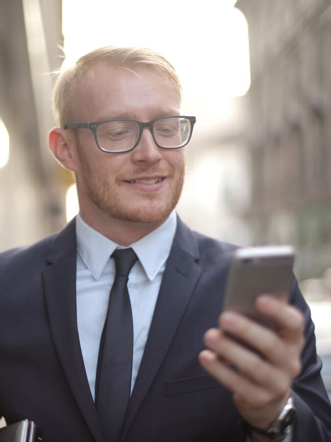 Young executive smiling at a text on his phone