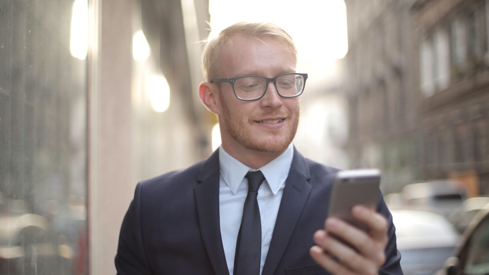 Young executive smiling at a text on his phone